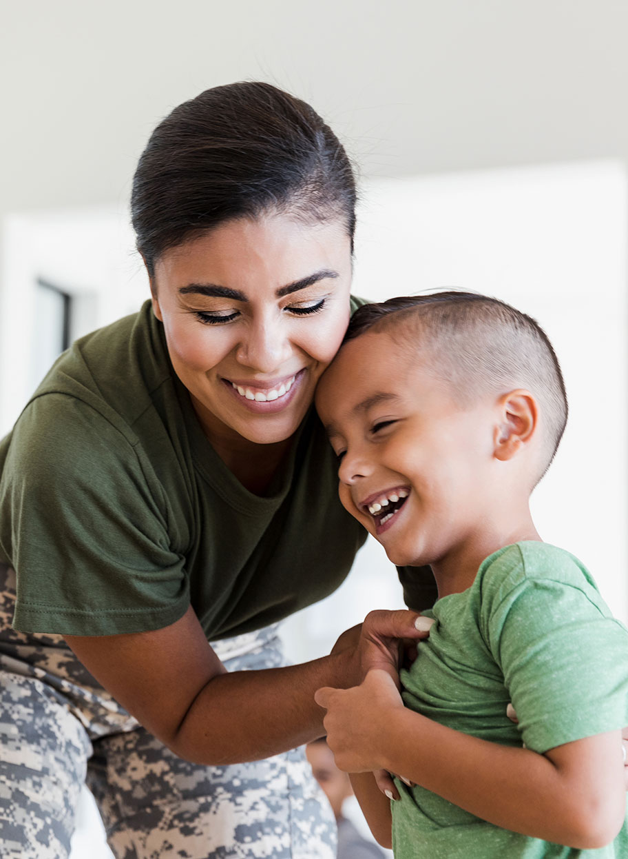 Mom in military uniform plays with her young male child